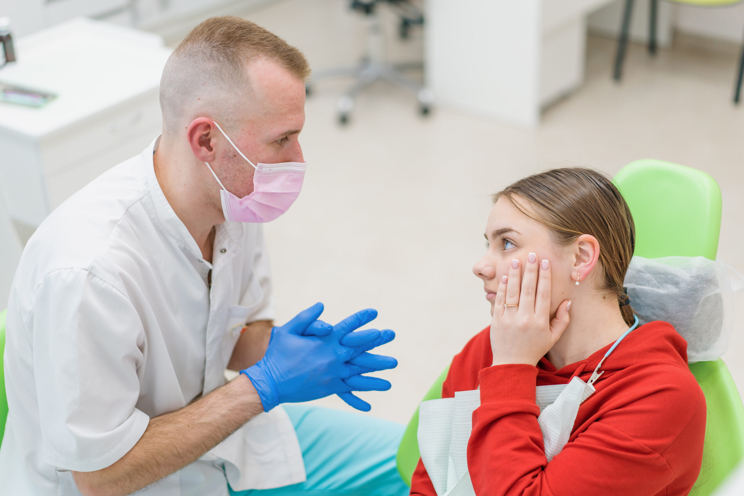 Girl having serious tmj pain consulting a dentist 